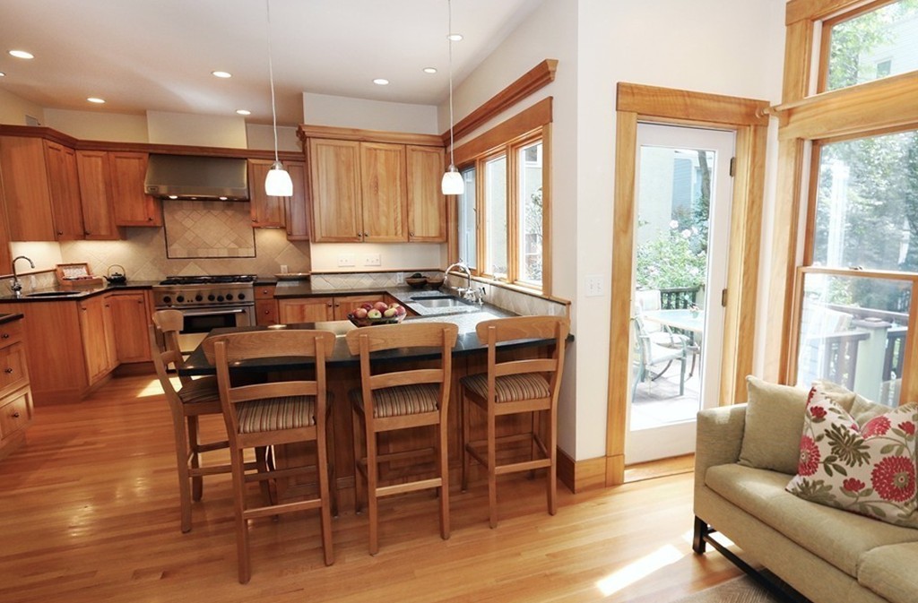 166 Chestnut Street Cambridge, MA 02139 - Photo 4 of 30 a kitchen with stainless steel appliances granite countertop a stove a refrigerator a kitchen island a table and chairs