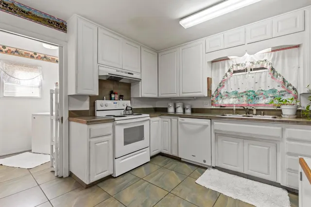 a kitchen with white cabinets and white appliances