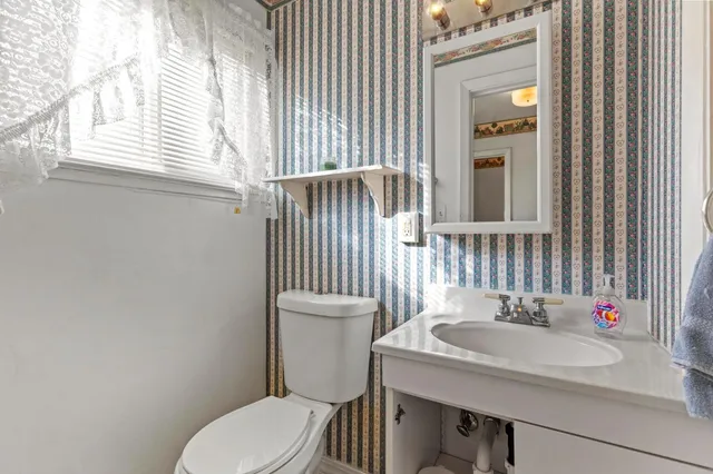 a bathroom with a sink a toilet and a mirror