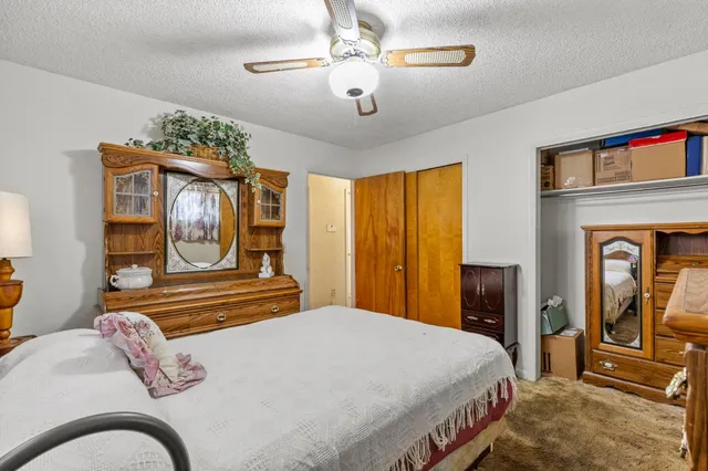 a bedroom with a bed and dresser with mirror