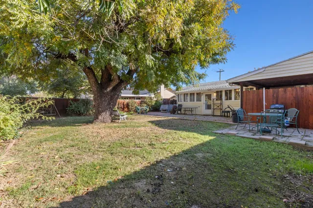 a backyard of a house with table and chairs
