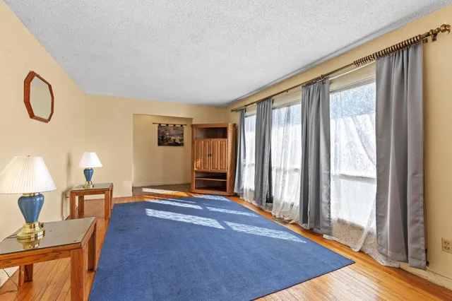 a view of a livingroom with furniture wooden floor and windows