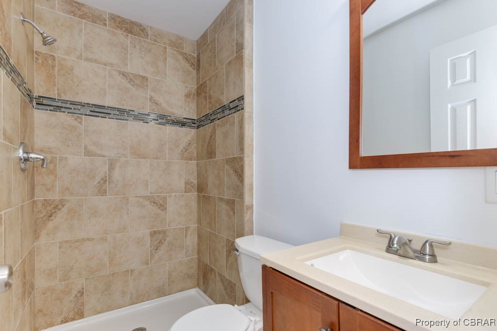 8729 Marlfield Road Gloucester, VA 23061 - Photo 27 of 32 Bathroom with toilet, vanity, and tiled shower