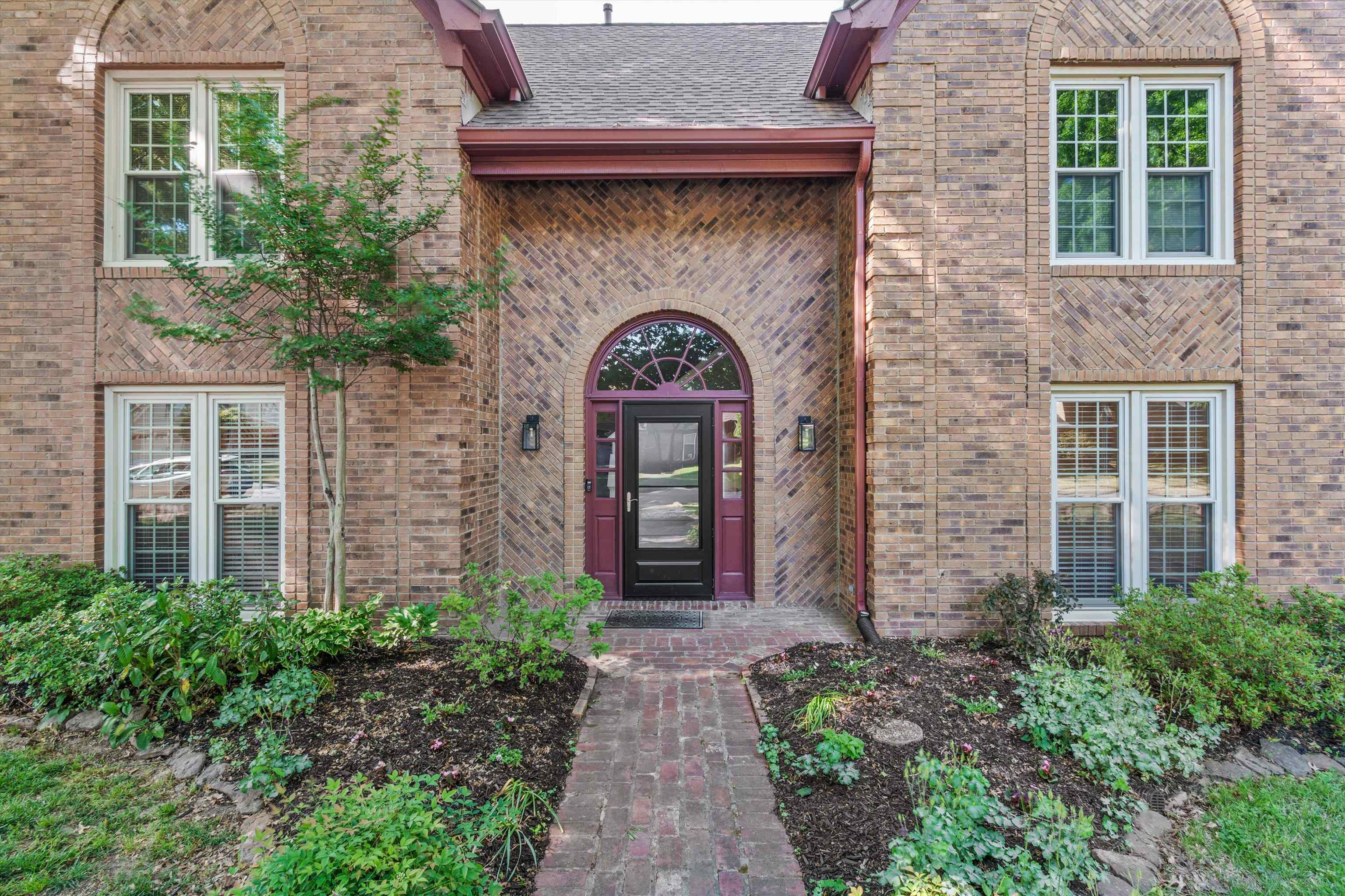 10288 Waterford Road Collierville, TN 38017 - Photo 2 of 35 Charming brick façade welcomes you with a beautifully framed arched entry and classic iron-accented front door. Surrounded by mature landscaping and a brick walkway, this inviting Front Porch sets a warm and timeless first impression.
