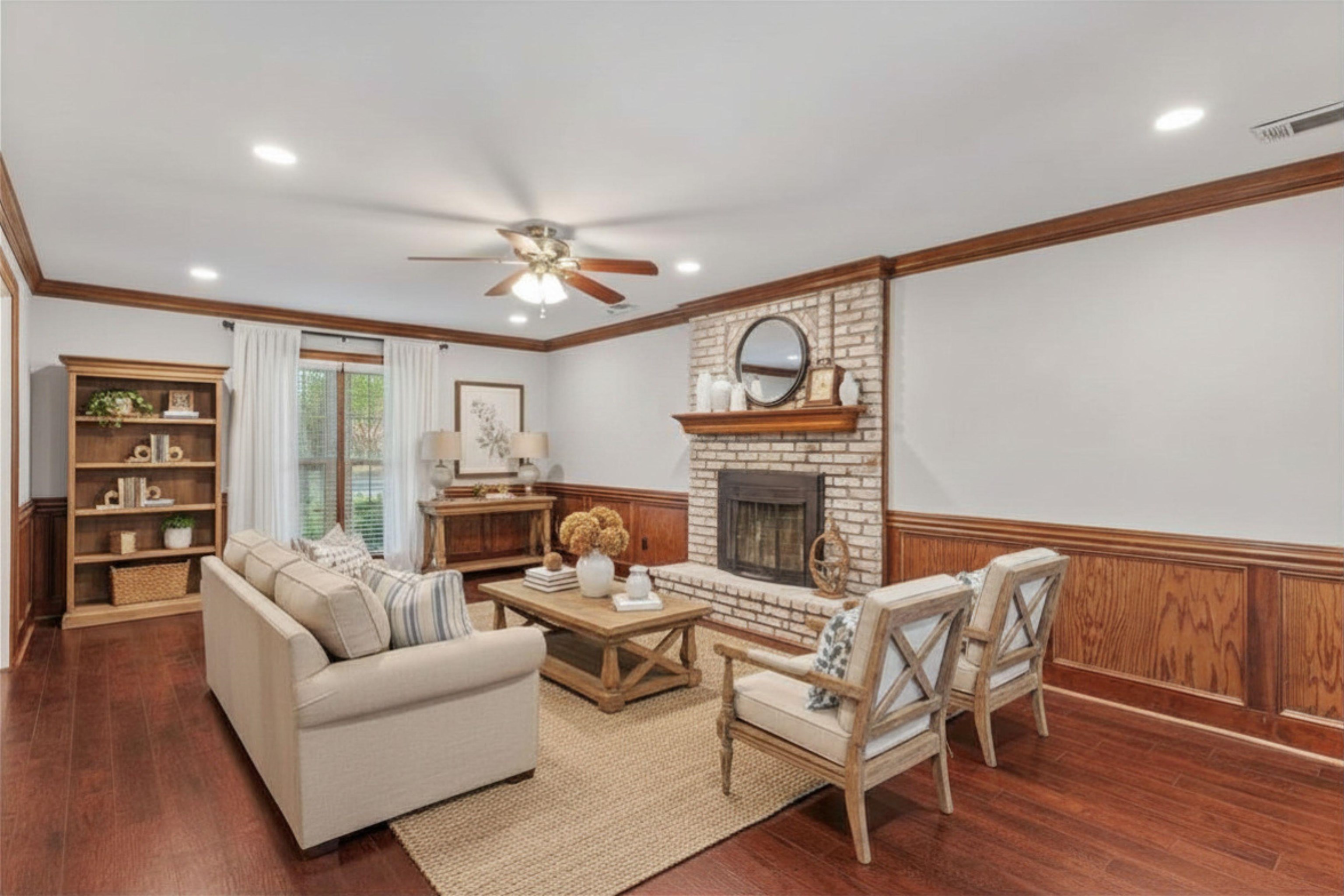 10288 Waterford Road Collierville, TN 38017 - Photo 5 of 35 Elegant crown molding, LVP floors, and a cozy wood fireplace with a raised brick hearth—overlooking the covered patio and lush rear grounds. Virtually Staged Photo