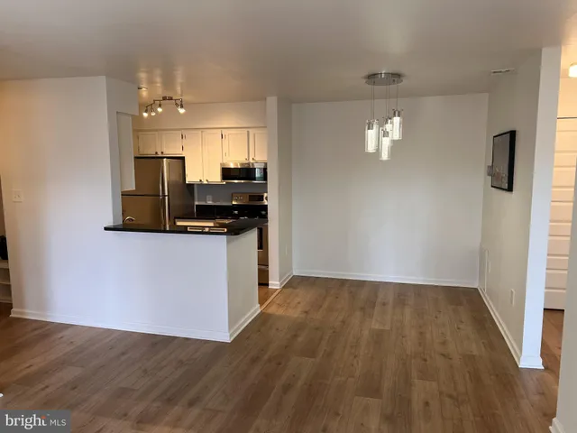 a view of a kitchen with wooden floor and cabinets