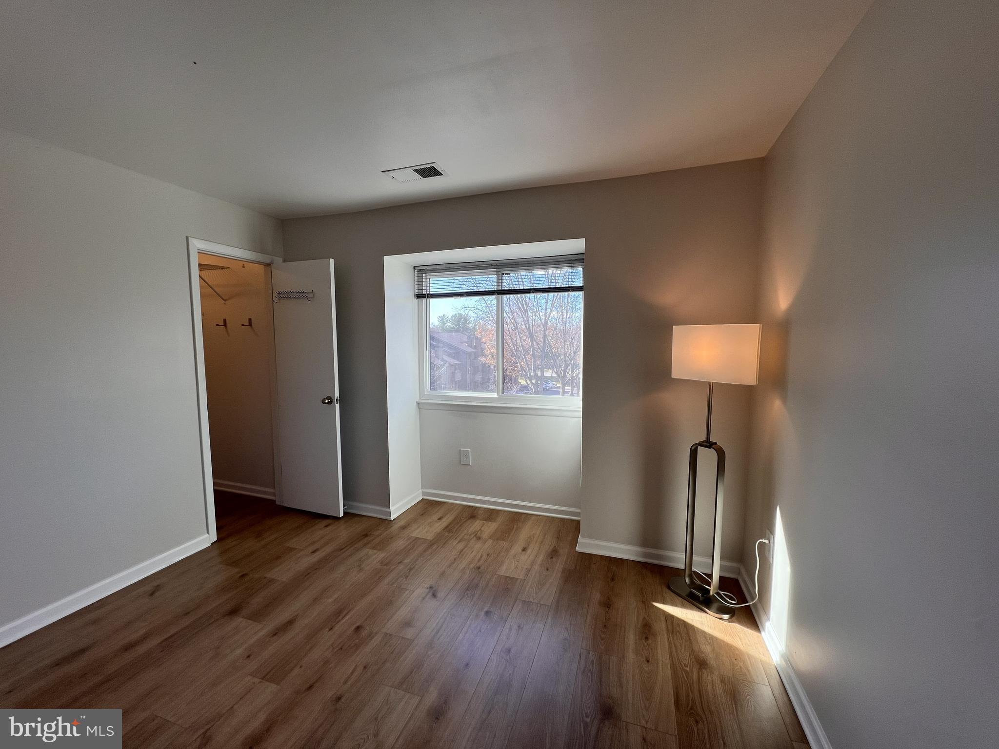 5355 Smooth Meadow Way, Unit 5 Columbia, MD 21044 - Photo 11 of 27 an empty room with wooden floor and windows