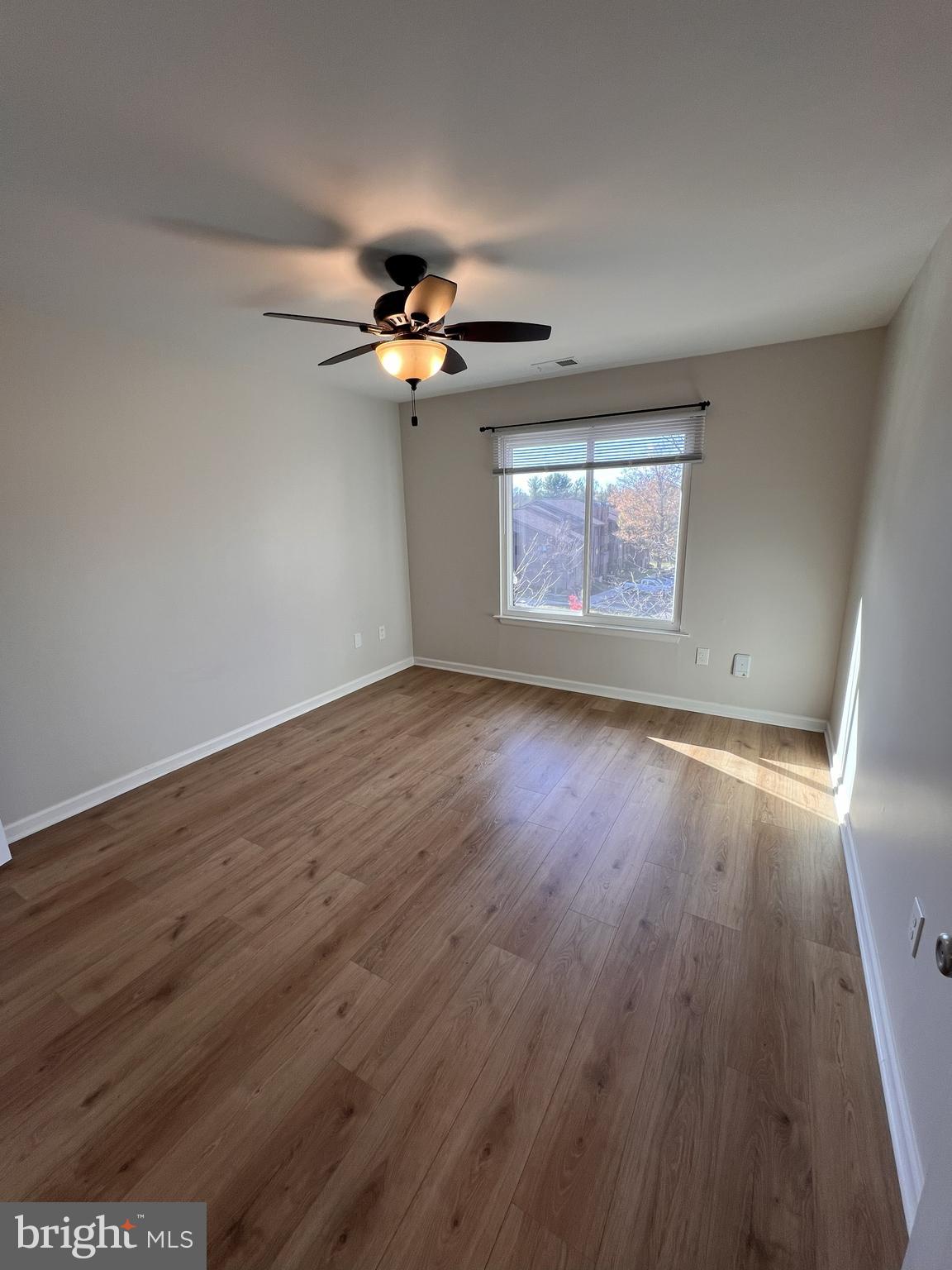 5355 Smooth Meadow Way, Unit 5 Columbia, MD 21044 - Photo 17 of 27 a view of an empty room with wooden floor and a window