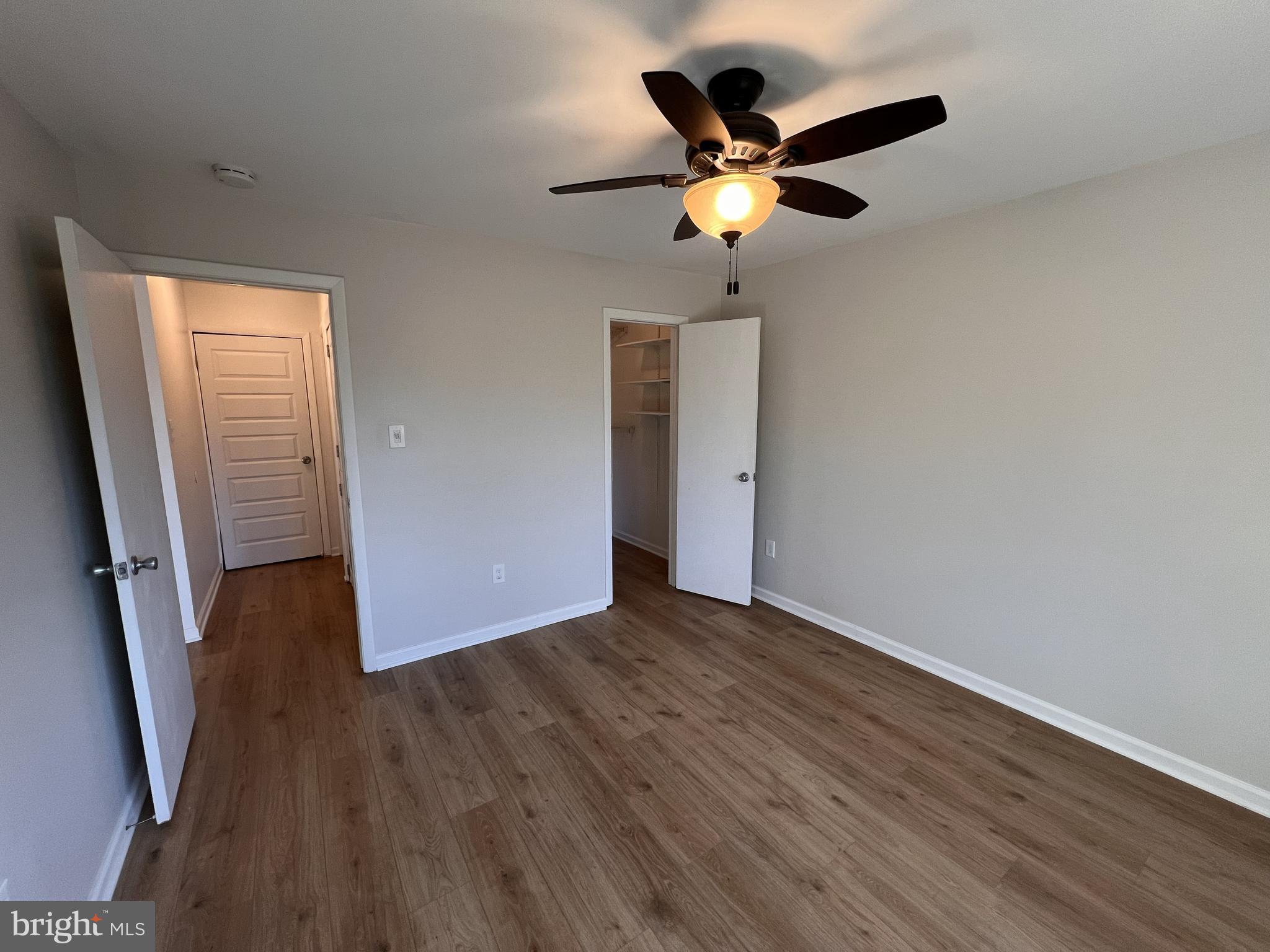 5355 Smooth Meadow Way, Unit 5 Columbia, MD 21044 - Photo 18 of 27 an empty room with wooden floor and a ceiling fan