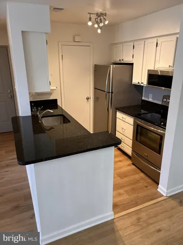 a kitchen with granite countertop a refrigerator and a sink