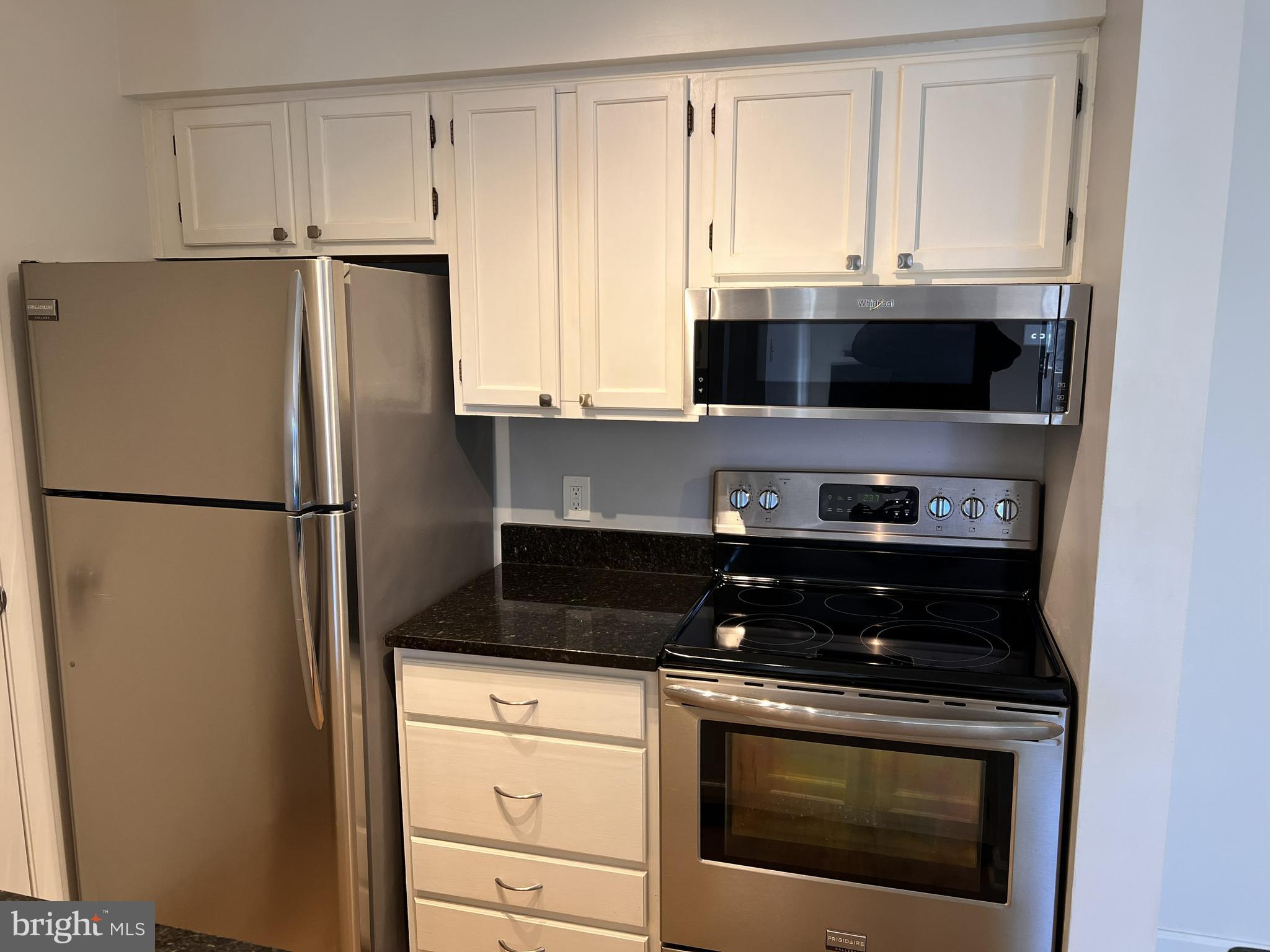 5355 Smooth Meadow Way, Unit 5 Columbia, MD 21044 - Photo 5 of 27 a kitchen with white cabinets and black appliances