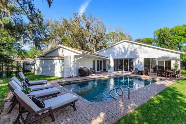a view of house with swimming pool yard and outdoor seating