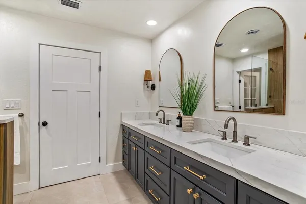 a bathroom with a double vanity sink mirror and shower