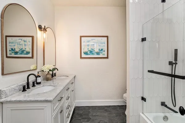 a bathroom with a tub sink and mirror