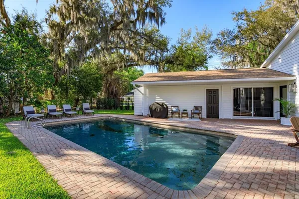 a view of a house with swimming pool and a porch with furniture