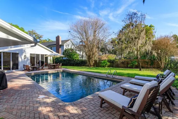 a view of a swimming pool with lounge chairs in patio