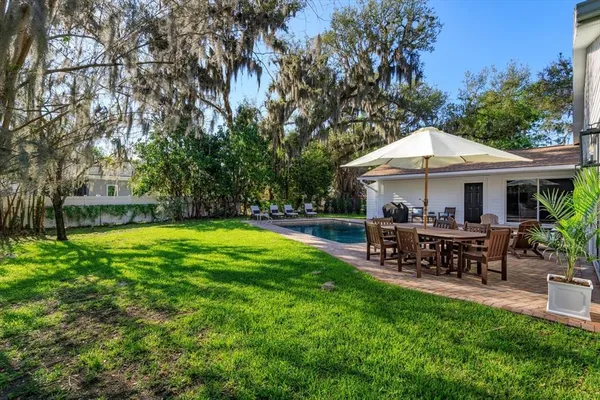 a view of a house with backyard and sitting area