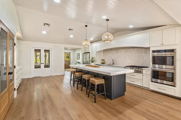 an open kitchen with a sink and stove top oven