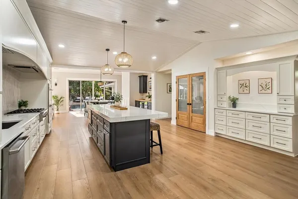 a large kitchen with stainless steel appliances lots of counter space and wooden floors