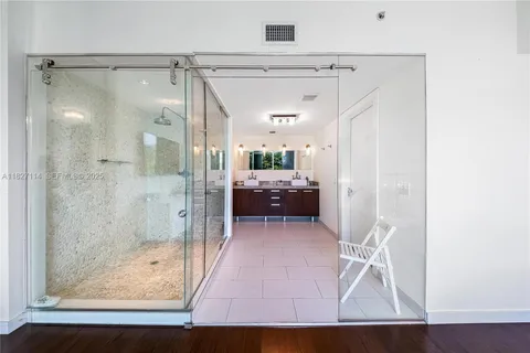 a bathroom with a glass shower door and a glass door
