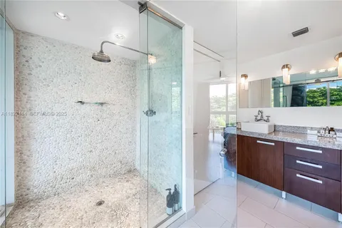 a bathroom with a granite countertop sink a shower and a mirror