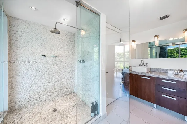 a bathroom with a granite countertop sink a shower and a mirror