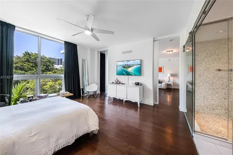 a spacious bedroom with a bed and a large window