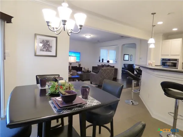 a living room with furniture a chandelier and a dining room