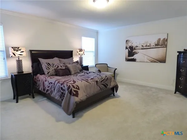 a large bed sitting in a bedroom next to a lamp