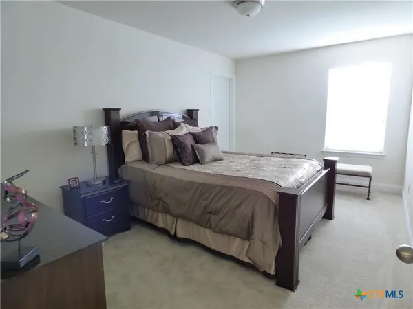 a spacious bedroom with a bed and a window