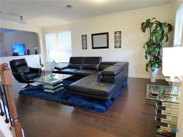 a living room with furniture kitchen view and a potted plant