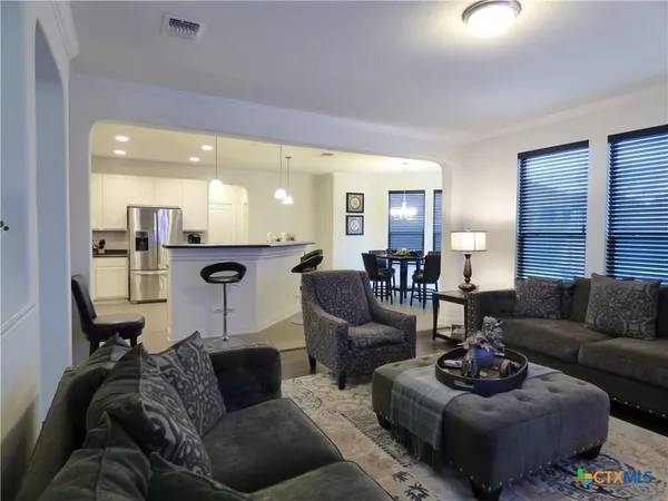 a living room with furniture and a view of kitchen