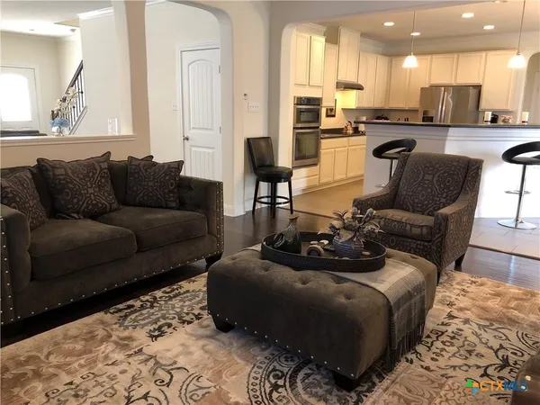 a living room with furniture and a view of kitchen