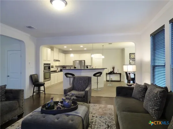 a living room with furniture and a view of kitchen