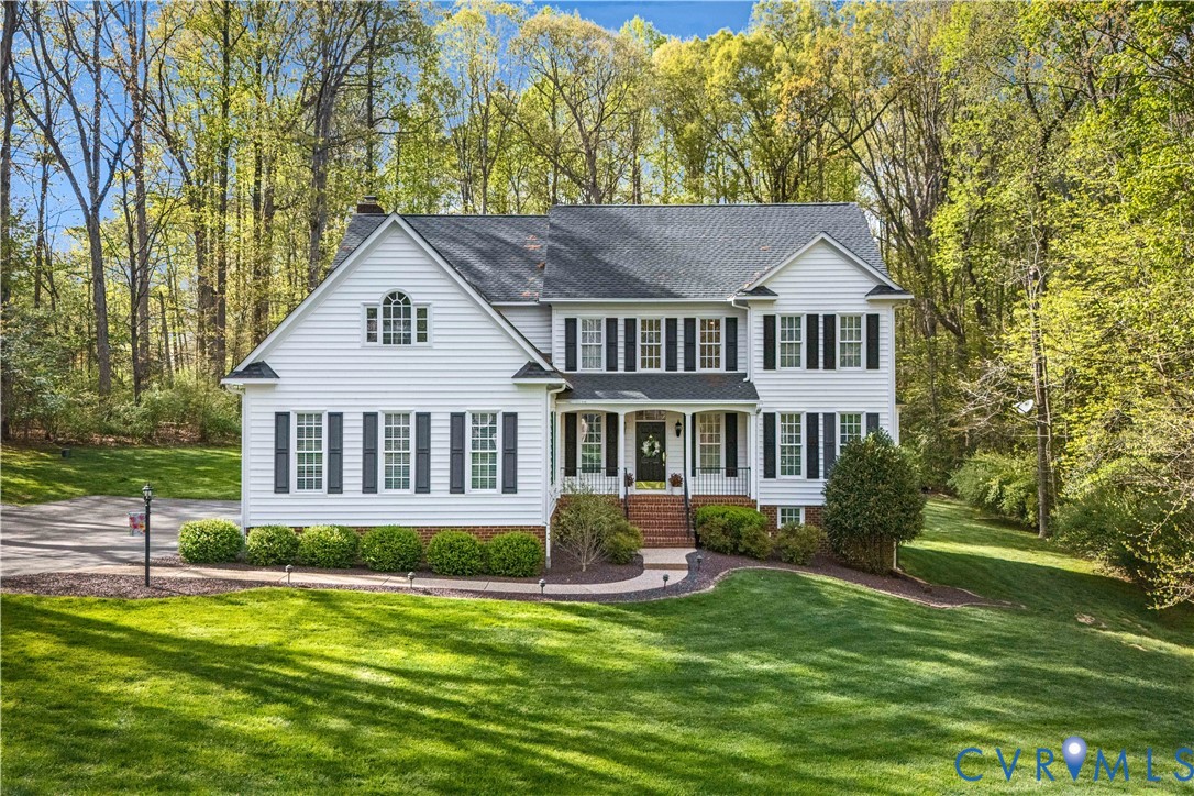 a front view of a house with a yard and trees