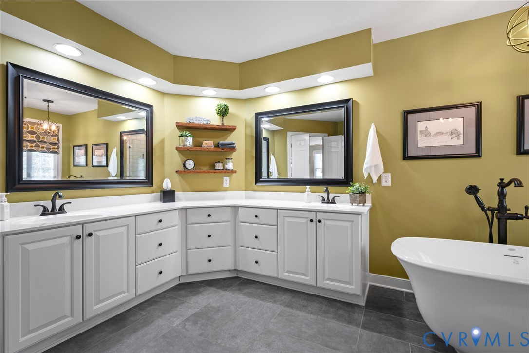 638 Cross Ridge Lane Manakin-Sabot, VA 23103 - Photo 27 of 54 a spacious bathroom with a double vanity sink a large mirror and a bathtub