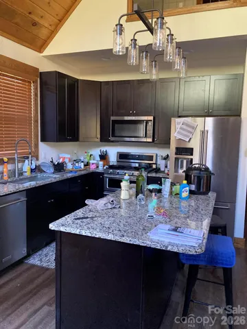 a kitchen with stainless steel appliances granite countertop a sink wooden cabinets and a granite counter tops