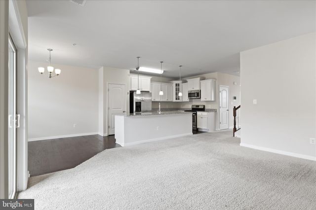 a view of a kitchen with refrigerator and white cabinets