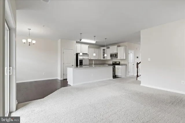 a view of a kitchen with refrigerator and white cabinets