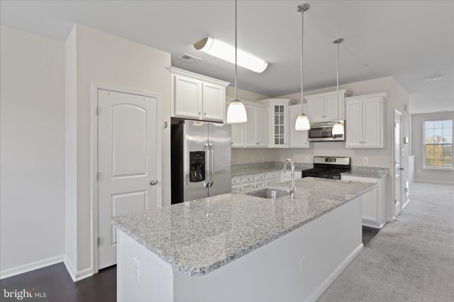 a kitchen with stainless steel appliances granite countertop a sink refrigerator and cabinets