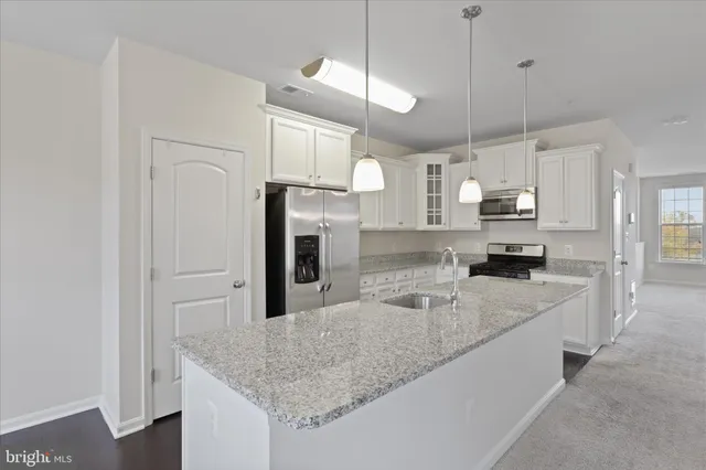 a kitchen with stainless steel appliances granite countertop a sink refrigerator and cabinets