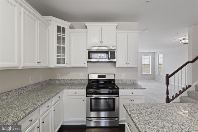 a kitchen with granite countertop a stove and a sink