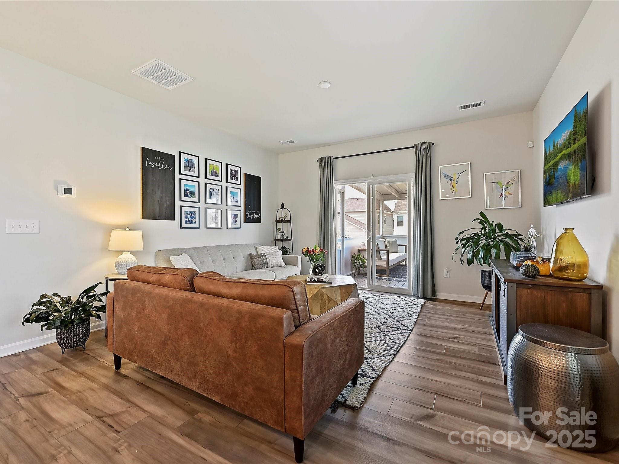 5807 Soft Shell Drive Lancaster, SC 29720 - Photo 7 of 33 a living room with furniture a flat screen tv and a potted plant