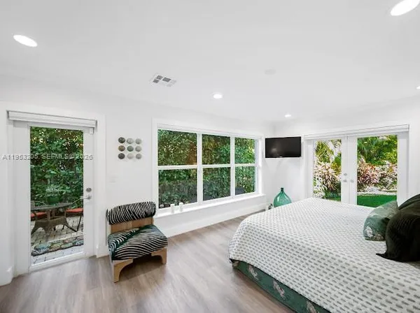 a bedroom with a bed and a large window