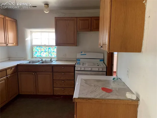 a kitchen with granite countertop wooden cabinets and window