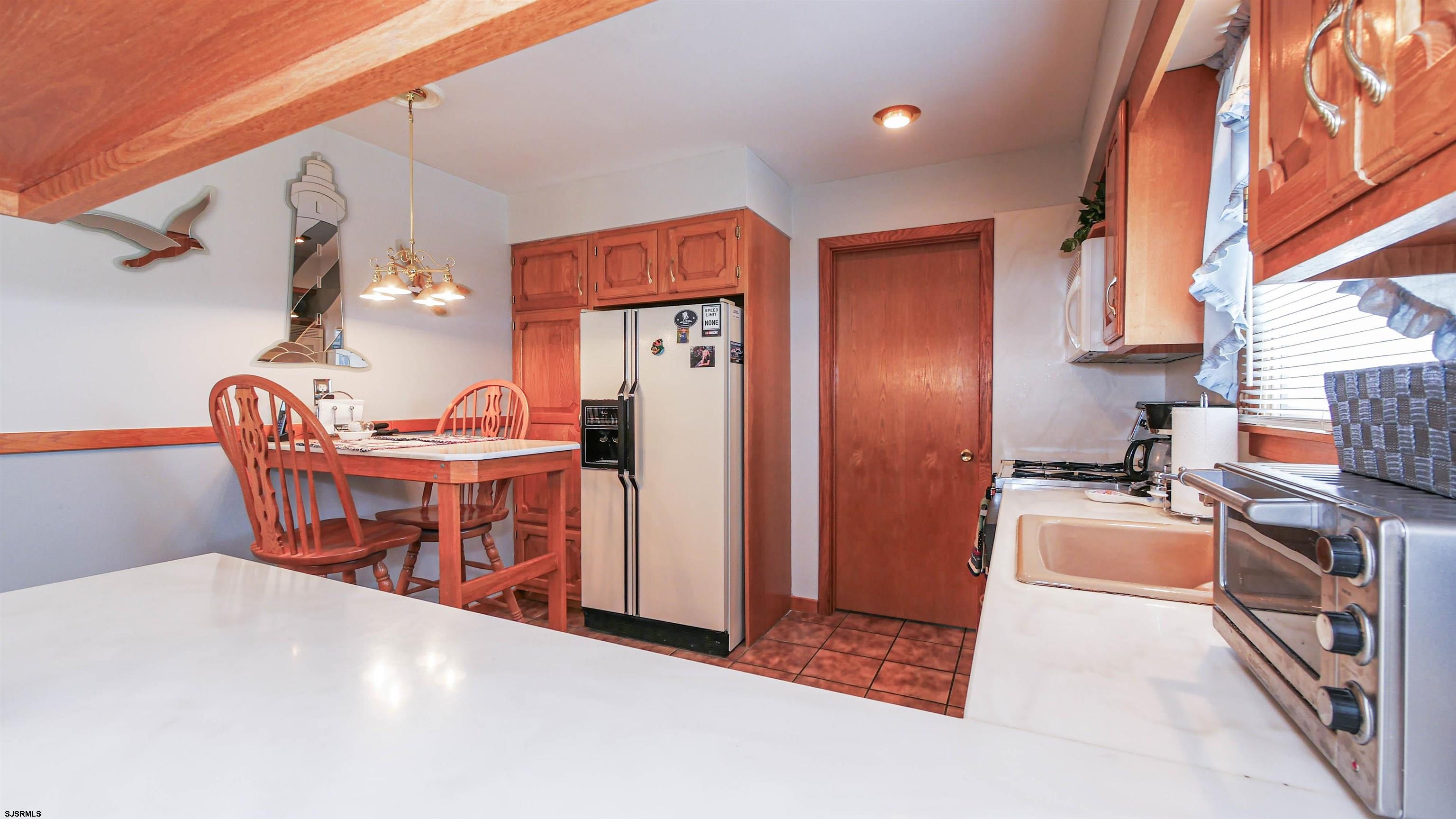 2042 Sutton Avenue Northfield, NJ 08225 - Photo 11 of 32 a kitchen with stainless steel appliances granite countertop a refrigerator a stove a sink and a dining table with granite countertops