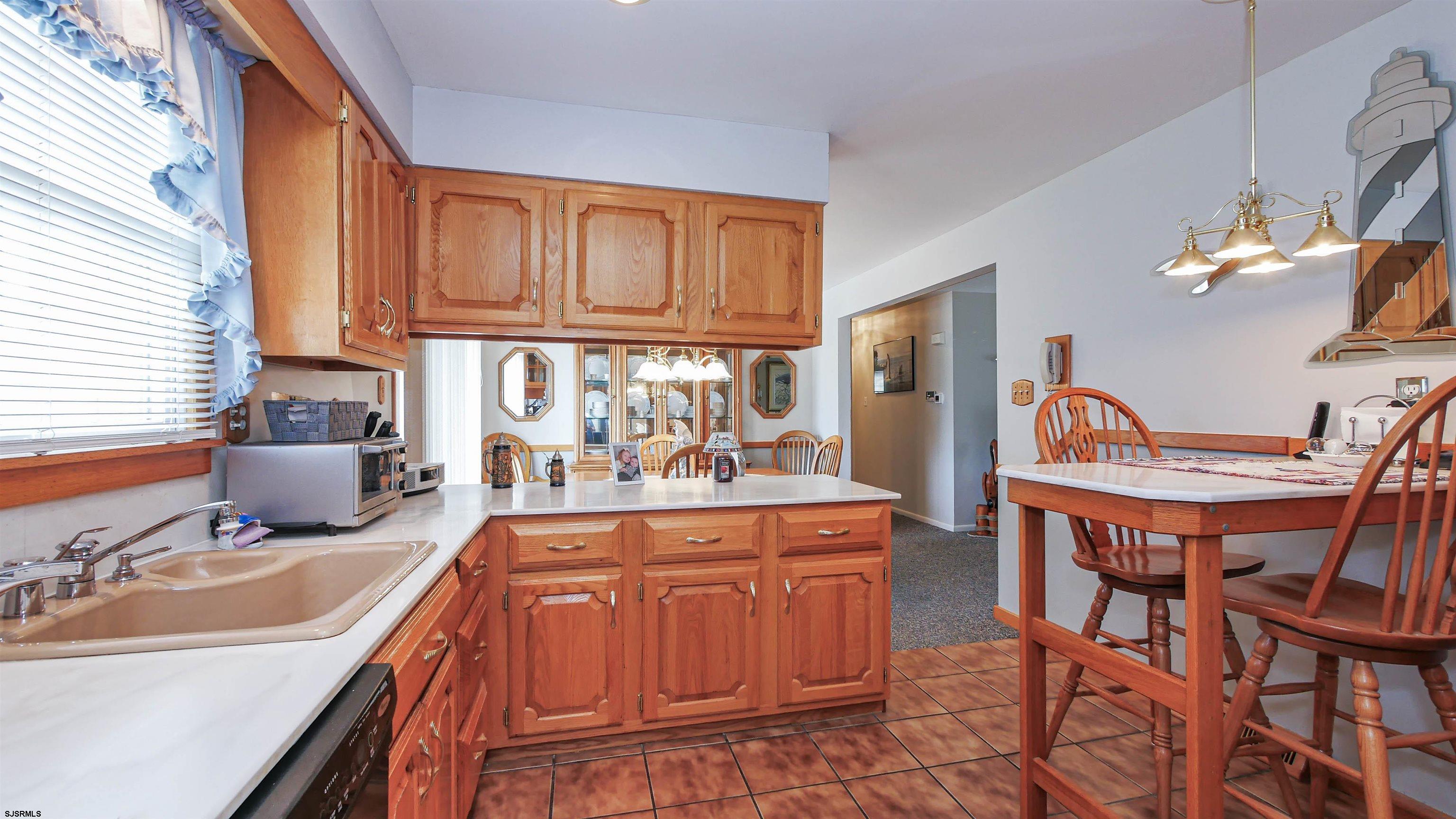 2042 Sutton Avenue Northfield, NJ 08225 - Photo 13 of 32 a kitchen with stainless steel appliances granite countertop a dining table chairs and granite counter tops