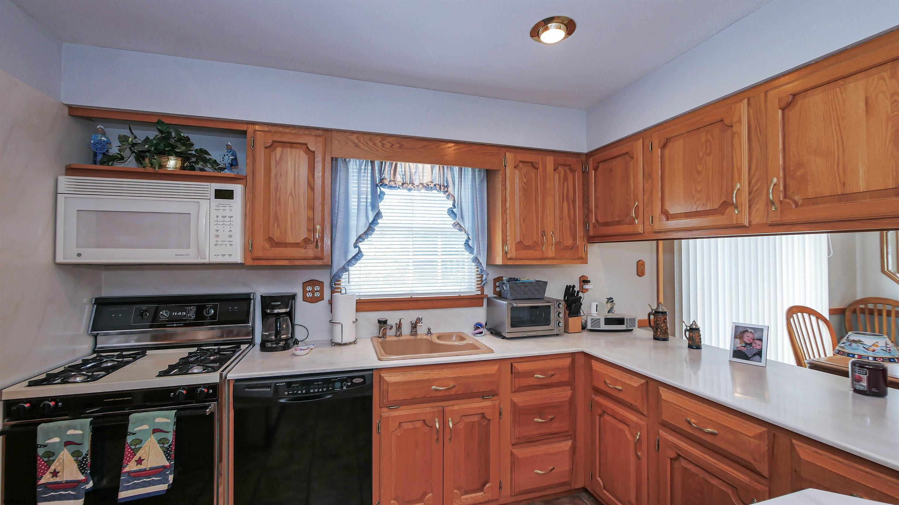 2042 Sutton Avenue Northfield, NJ 08225 - Photo 14 of 32 a kitchen with stainless steel appliances granite countertop a sink stove and cabinets