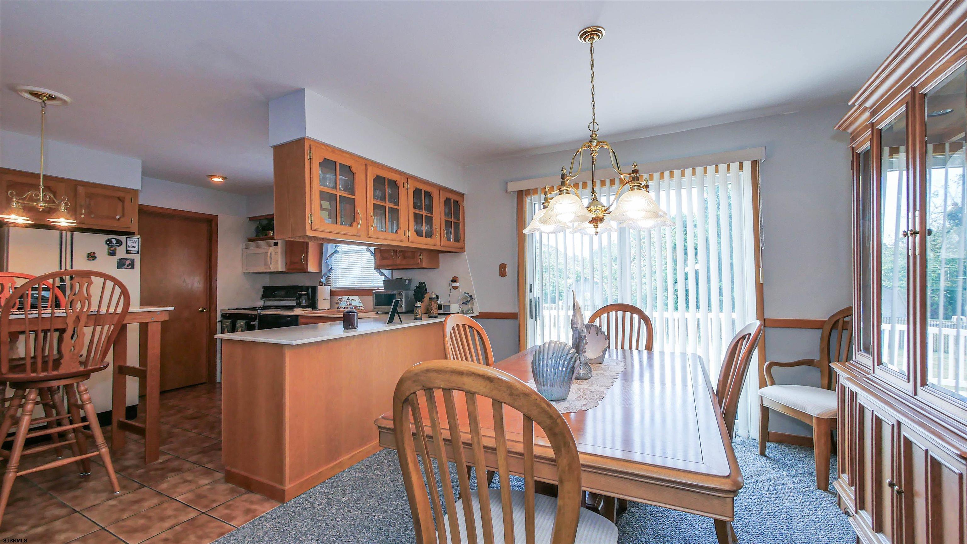 2042 Sutton Avenue Northfield, NJ 08225 - Photo 9 of 32 a dining room with furniture a chandelier and wooden floor