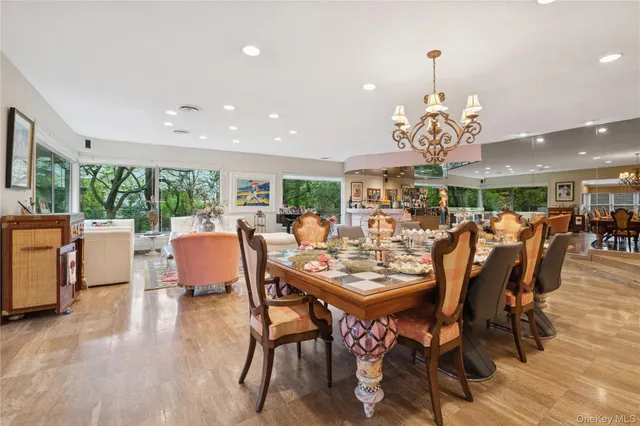 a view of a dining room and livingroom with furniture a chandelier and wooden floor